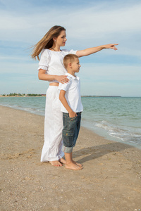 母亲和她的儿子在沙滩上玩