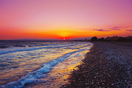 地中海沿岸美丽的日落。卵石石滩