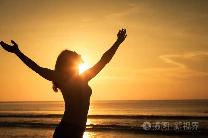 女人张开的双臂下日出海上