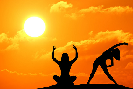 女人在海边日落期间练习瑜伽的剪影照片