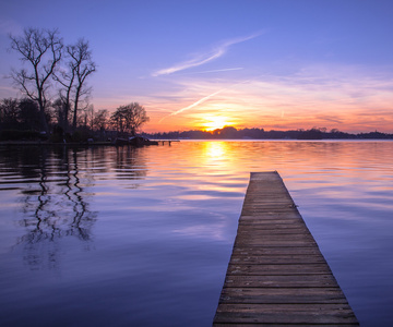 宁静日落反映在水中与日俱增的木码头