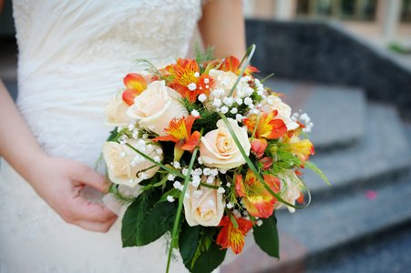 新娘抱着一束玫瑰的美丽的婚纱