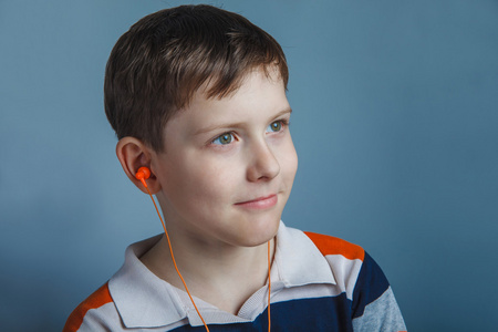 欧洲人的小男孩戴着耳机听十年