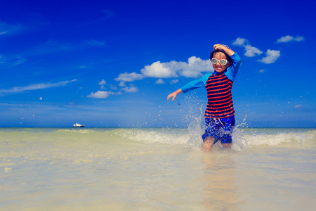 泼水热带海滩上的小男孩