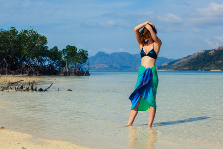 女人穿纱笼热带海滩上