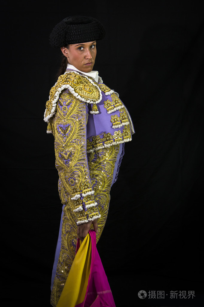 持有卡波特粉色黑色背景上的女斗牛士