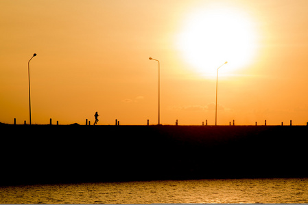 女人正在夕阳中奔跑剪影