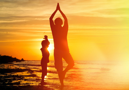 父亲和儿子在日落时分做瑜伽