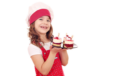 快乐的小女孩用甜甜的覆盆子蛋糕做饭