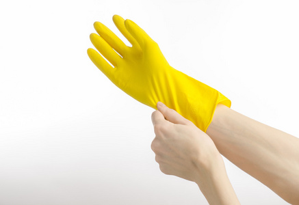 家庭作业，洗涤和清洁的主题 持有黄色和戴橡胶手套清洗分离在工作室中的白色背景上的人的手