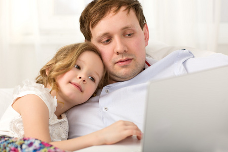 父亲和小女儿使用笔记本电脑