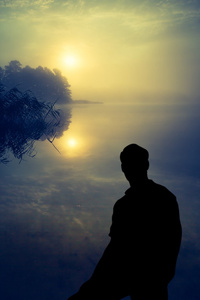 在湖上看日出的人。人体轮廓
