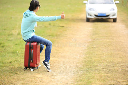 年轻女子搭便车沿路而行。