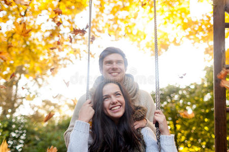 微笑的情侣在秋天公园拥抱