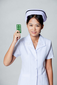 年轻亚洲护士展示药片包