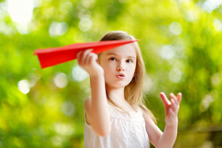 可爱的小女孩拿着纸飞机