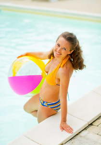 游泳池中微笑的年轻女子画像
