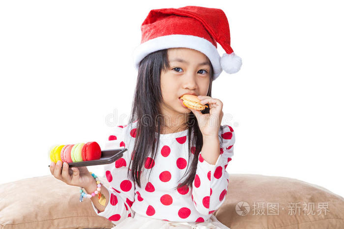 给圣诞老人端着一盘饼干的小女孩
