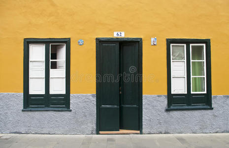 黄墙上的门和两扇窗户