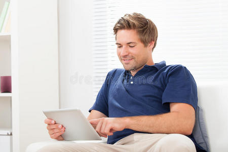 在家沙发上用数字平板电脑的男人