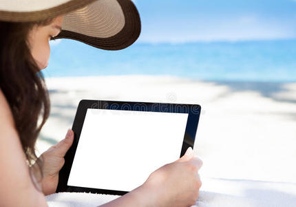沙滩上拿着数字平板电脑的女人