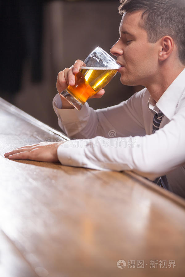 一个孤独的年轻人独自在酒吧喝酒