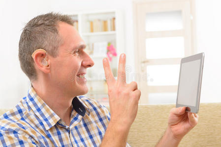 聋子在平板电脑上使用手语照片