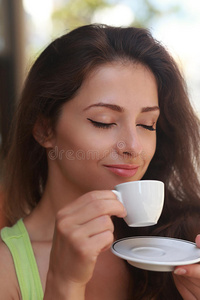 美丽的女人一边喝咖啡一边享受
