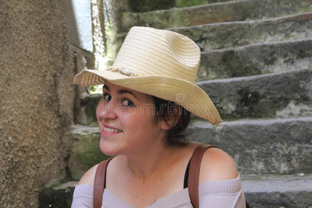 年轻女子微笑着，戴着帽子