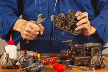 修理工在车间修理旧汽车发动机零件