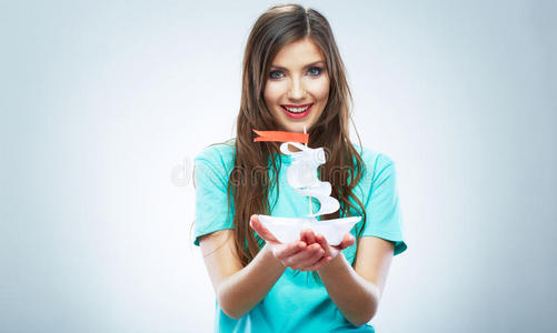 年轻微笑的女人手持白纸船的肖像。女性m