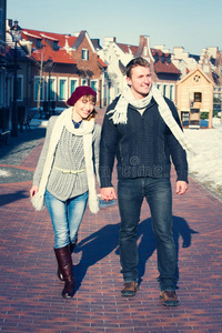 一对年轻夫妇在冬天在城里走来走去。