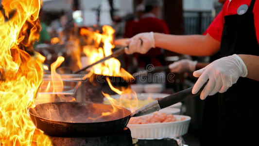 专业厨师在商业厨房烹饪火焰风格照片