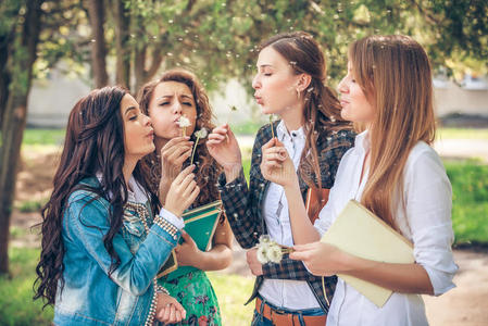 一群吹蒲公英种子的大学女生