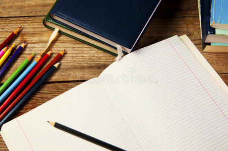 白纸和彩色铅笔，放在木桌上。从上面看。学校理念。