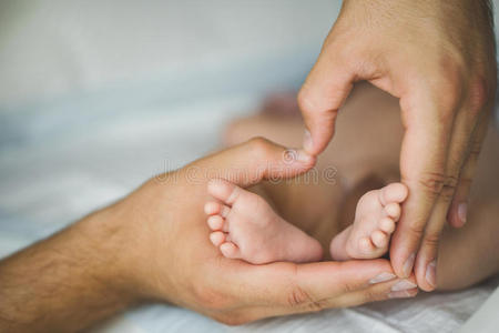 新生儿的脚放在母亲的手上。
