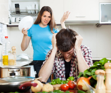 悲伤的男人和愤怒的妻子在厨房