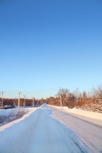 冬季积雪的路上，小镇在晴朗的日子里清澈的天空