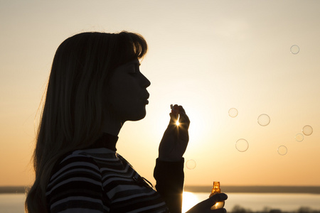 一个女孩与飞行肥皂泡沫的肖像