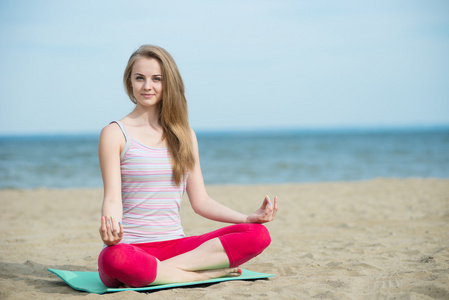 年轻的女士练习瑜伽。海洋海海岸附近的锻炼