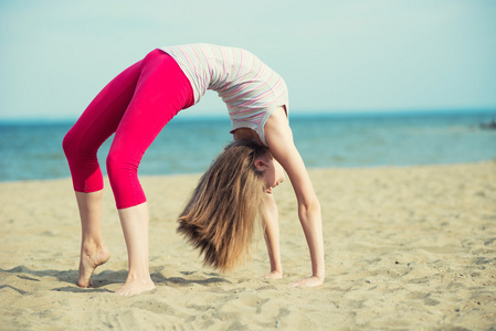 年轻的女士练习瑜伽。海洋海海岸附近的锻炼
