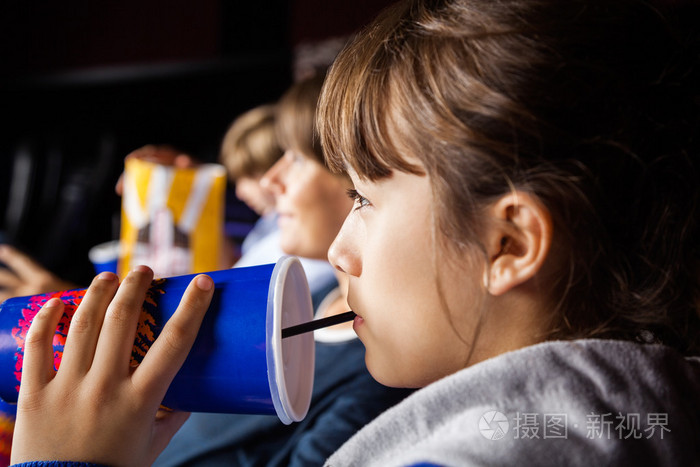 看电影在影院的时候喝可乐的女孩