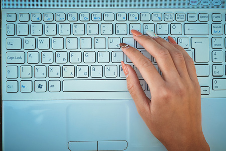 手放在键盘上的一台笔记本电脑
