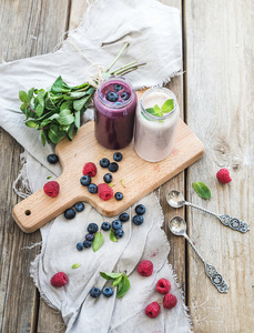 新鲜健康的果汁，蓝莓，覆盆子玻璃瓶和薄荷