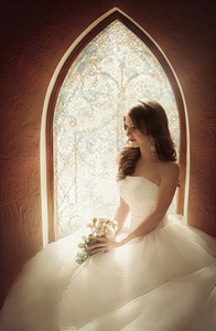 美丽的新娘坐在靠近窗口