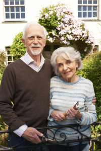 年长的夫妇在村舍花园工作