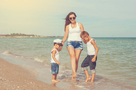 母亲和她在海滩上玩耍的两个儿子