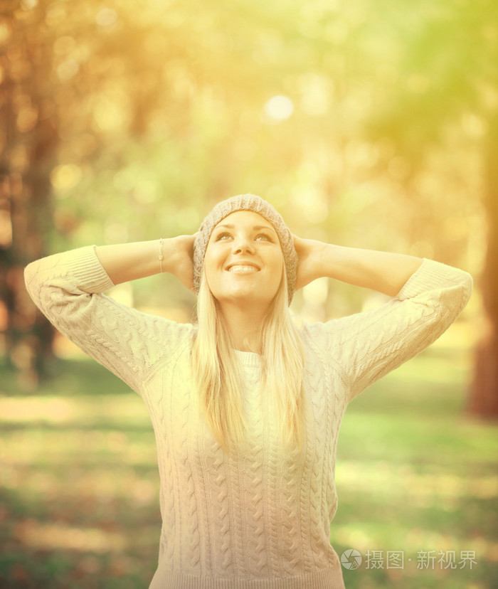 幸福的女人抬头看天空中秋天的树林