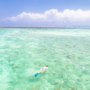 女人在绿松石蓝色海浮潜