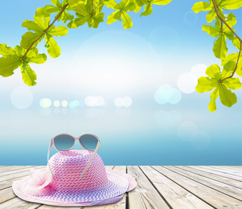帽子和太阳镜在热带海洋的木地板上
